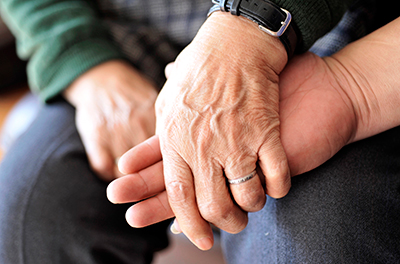 Two elderly people holding hands