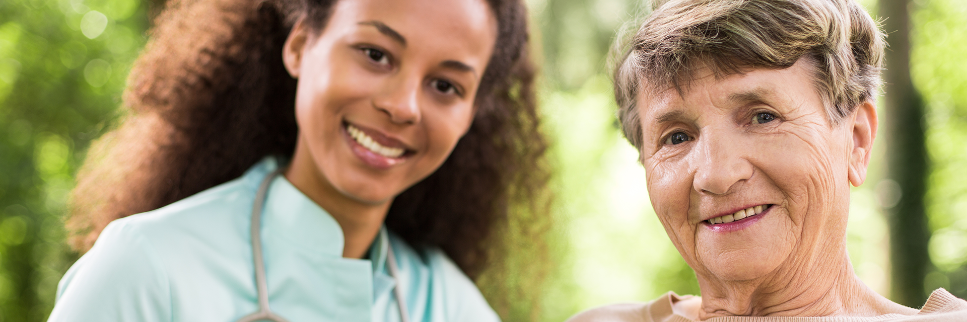 Nurse standing behind patient with hands on shoulders